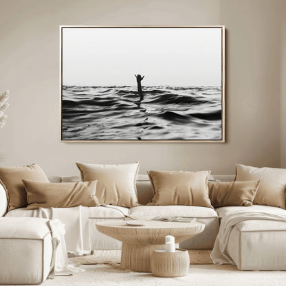 Black and white ocean with a hand making a surfer sign among dark waves, creating a dramatic and minimalist seascape with bold contrast.