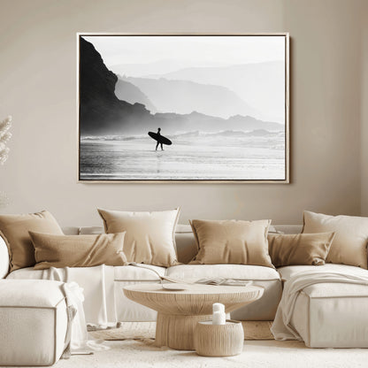A lone surfer walking along a misty beach with cliffs in the background, carrying their board, capturing a serene and minimal ocean moment.