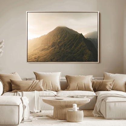 Sunlit mountain peak with mist rolling over its rugged slopes, bathed in golden light, creating a warm and tranquil nature-inspired scene.