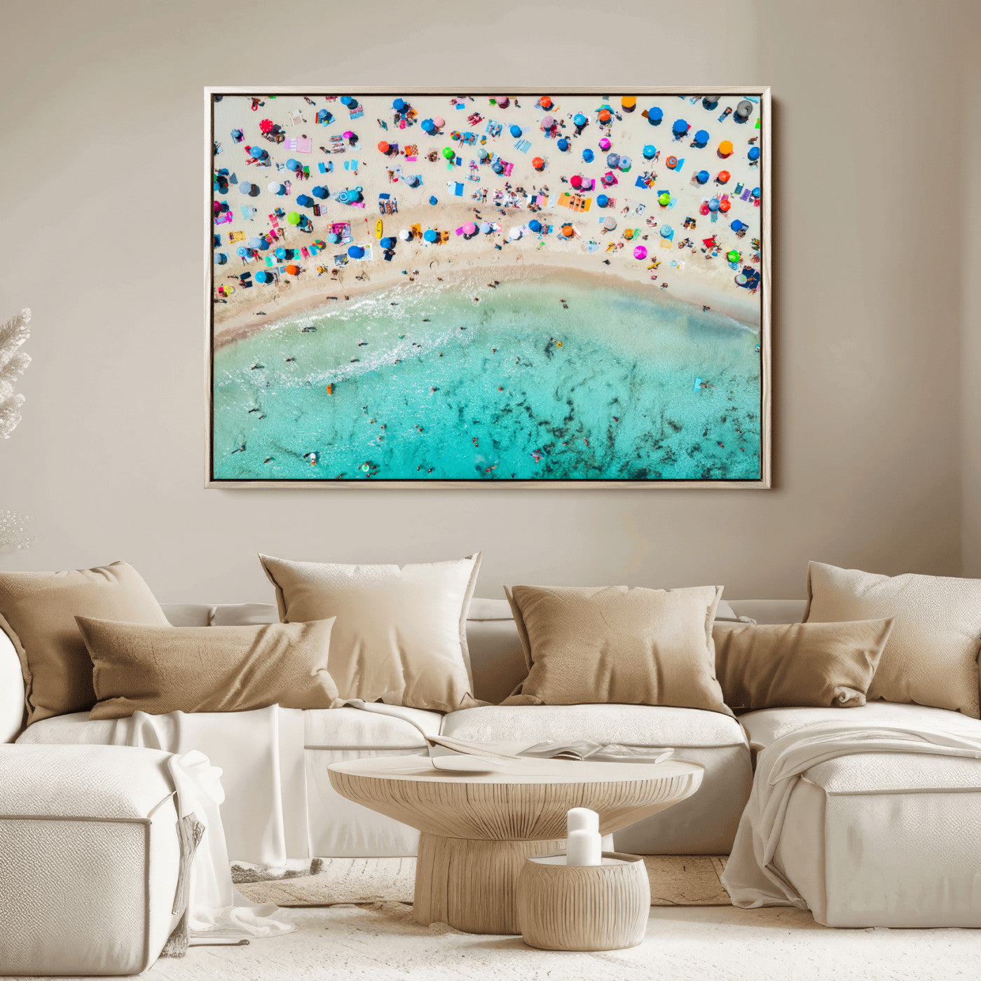 Aerial view of a vibrant beach filled with colorful umbrellas and people enjoying the turquoise ocean, capturing a lively summer vacation scene.