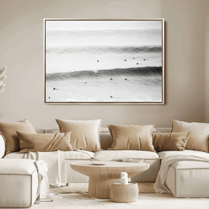 A monochrome photograph of swimmers gliding through gentle ocean waves, evoking a sense of calm and movement.