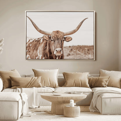 A longhorn cow in soft beige desert tones, standing calmly in open land, perfect for neutral western or rustic farmhouse interiors.