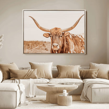 A longhorn bull standing proudly in a sunlit desert field with warm neutral tones, ideal for rustic western or farmhouse interiors.