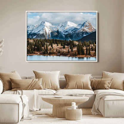 Framed canvas of snowy mountain peaks with pine forest and alpine lake, perfect for winter cabin or wilderness-inspired home decor.