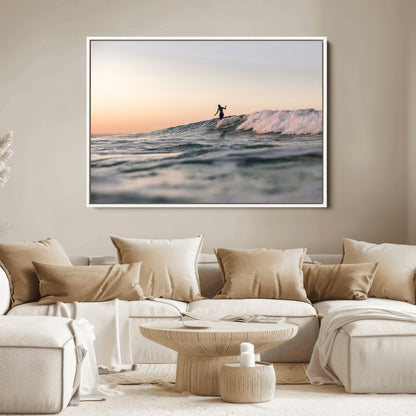 Framed canvas of a female surfer balancing on a wave at sunset, perfect for serene surf or ocean-inspired coastal decor.