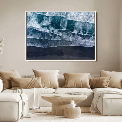 Canvas of aerial ocean waves crashing onto a black sand beach in moody tones, ideal for modern coastal or minimalist home decor.