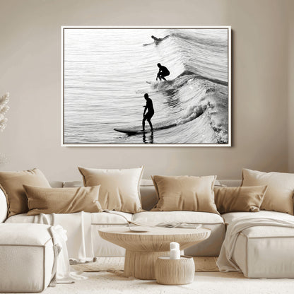 Black and white photo of surfers riding waves in a moody, high-contrast scene, ideal for modern coastal or surf-inspired home decor.