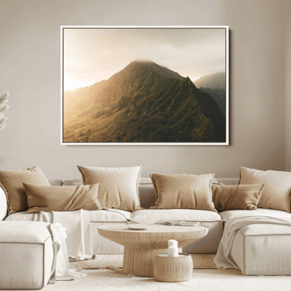 Sunlit mountain peak with mist rolling over its rugged slopes, bathed in golden light, creating a warm and tranquil nature-inspired scene.