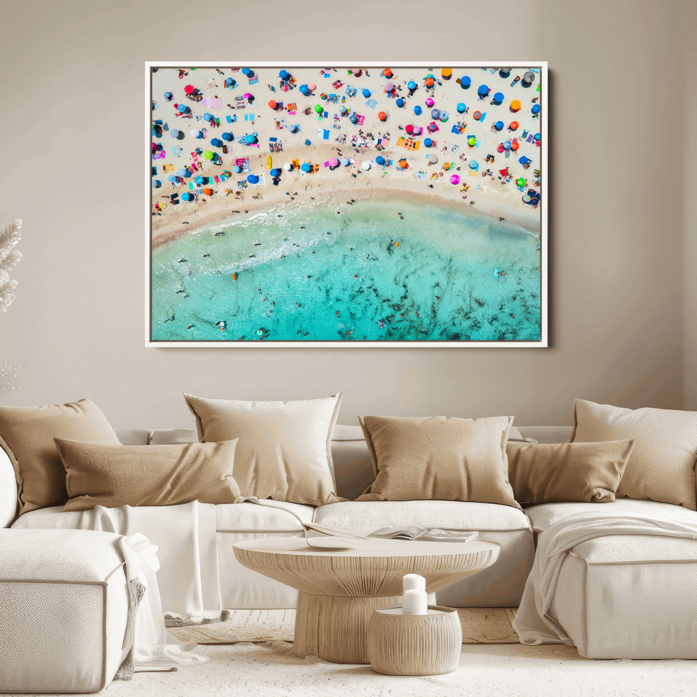 Aerial view of a vibrant beach filled with colorful umbrellas and people enjoying the turquoise ocean, capturing a lively summer vacation scene.