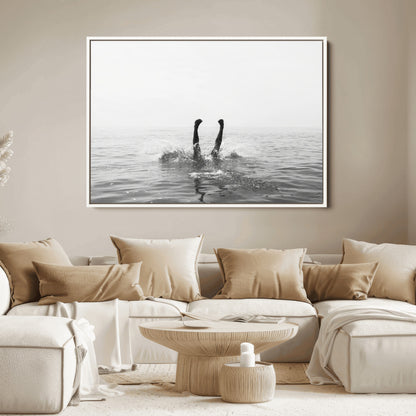 A black and white minimalist water scene capturing a playful splash as a swimmer dives upside down, creating a carefree and artistic aquatic aesthetic.