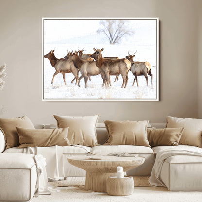 A group of elk standing on snowy terrain with a tree in the background, perfect for rustic or lodge-style winter wall decor.