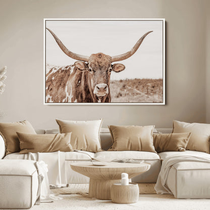 A longhorn cow in soft beige desert tones, standing calmly in open land, perfect for neutral western or rustic farmhouse interiors.