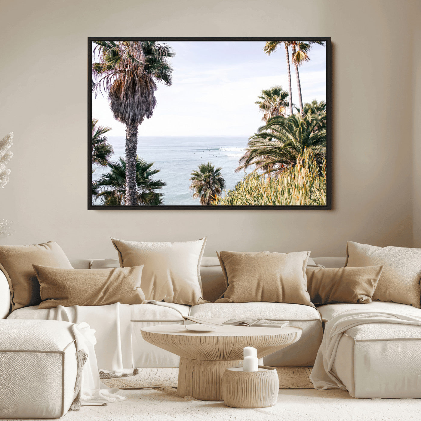 Scenic coastal view with tall palm trees overlooking a calm ocean, soft blue waves, and surfers in the distance, creating a peaceful tropical vibe.