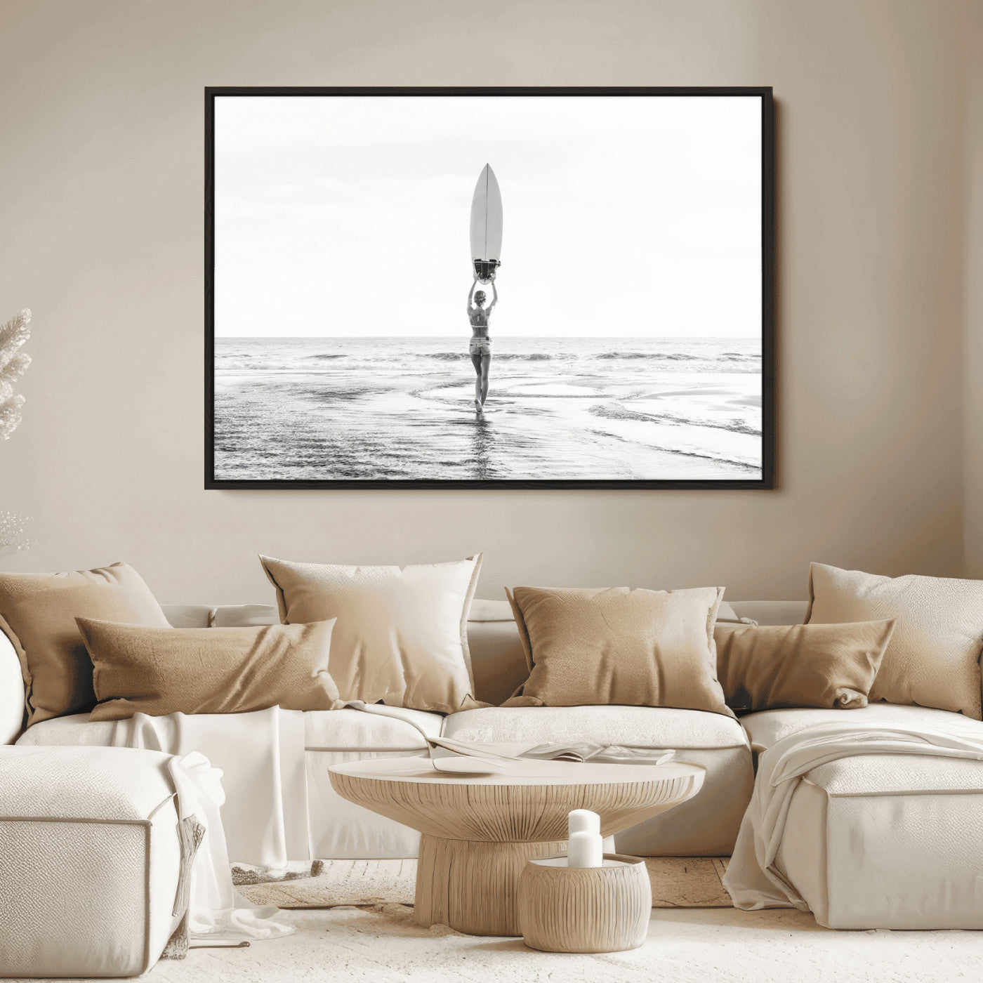 Black and white image of a female surfer holding a surfboard above her head while walking toward the ocean, creating a minimalist and bold coastal aesthetic.