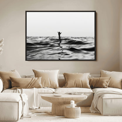 Black and white ocean with a hand making a surfer sign among dark waves, creating a dramatic and minimalist seascape with bold contrast.