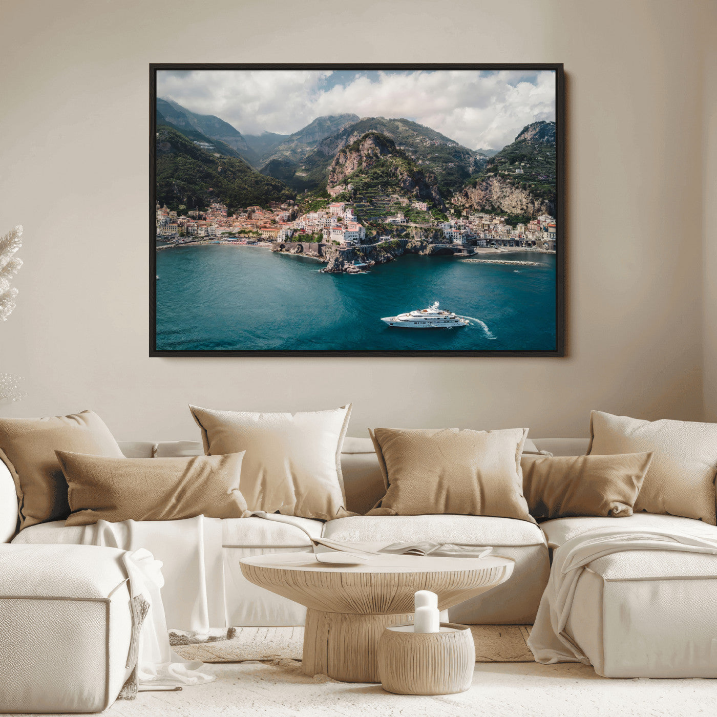 Aerial view of Amalfi Coast, Italy, with colorful hillside houses, lush green mountains, and a luxury yacht sailing in turquoise waters.