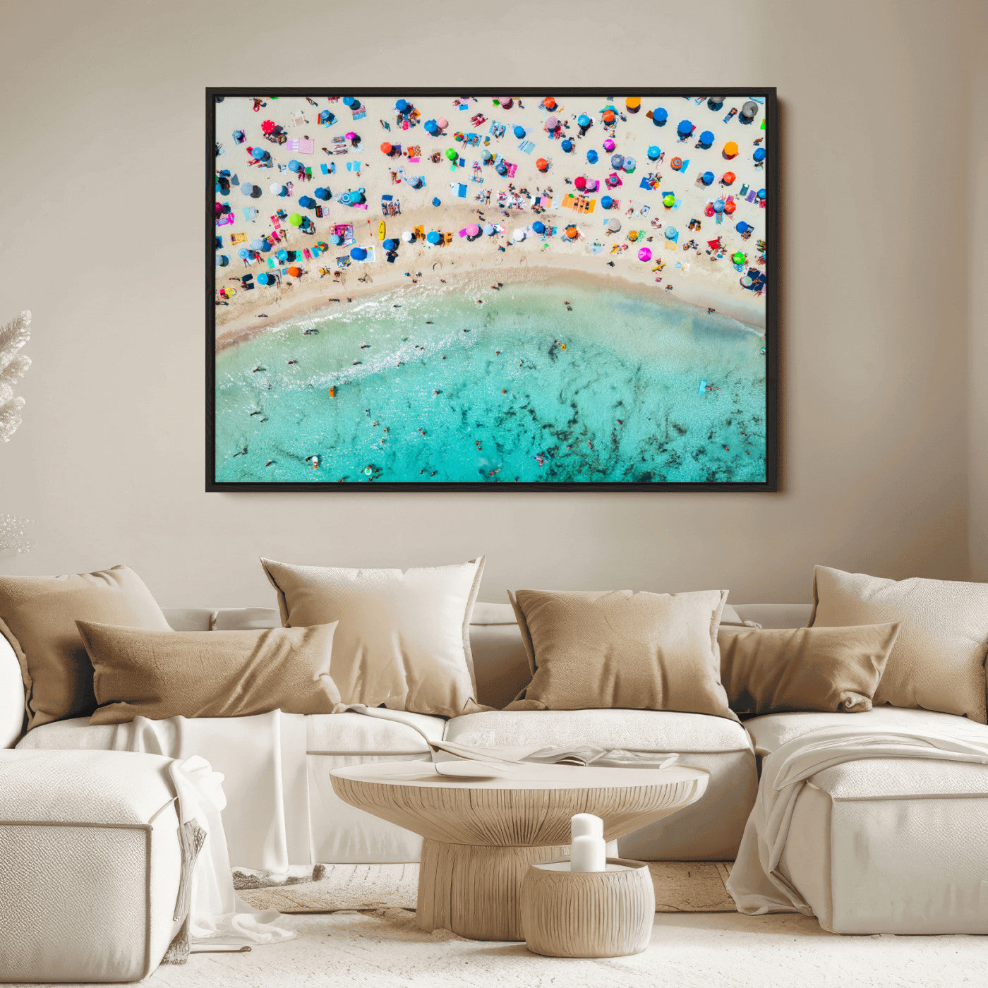 Aerial view of a vibrant beach filled with colorful umbrellas and people enjoying the turquoise ocean, capturing a lively summer vacation scene.