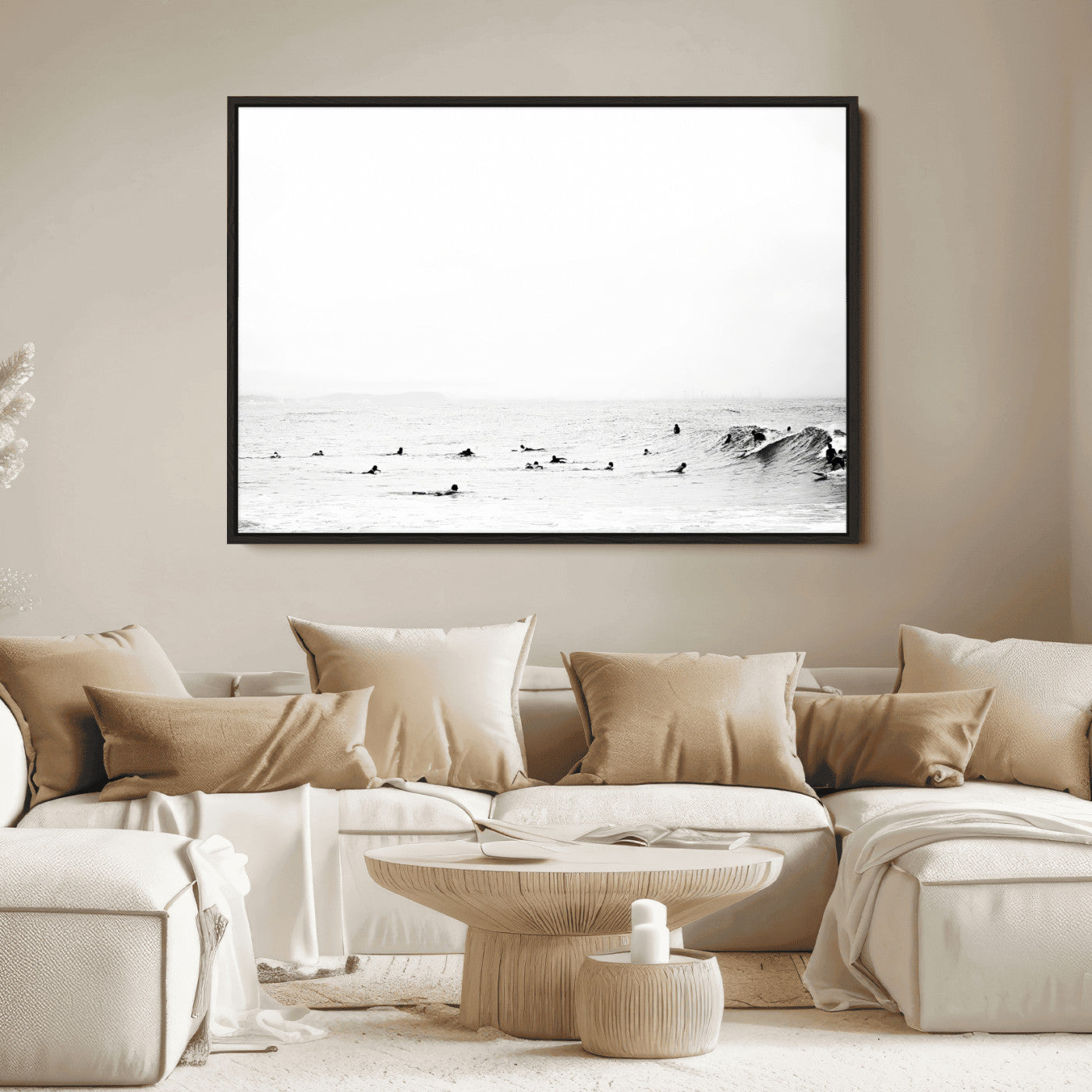 A group of surfers floating in the ocean, waiting for waves under a vast, moody sky, captured in black and white.