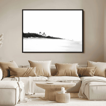 A black and white minimalist coastal scene with a vast open beach, distant palm trees, and a lone figure walking along the shoreline, evoking serenity and solitude.