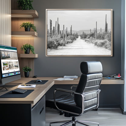 A black and white desert road stretching through a cactus-filled landscape, creating a rugged and timeless southwestern aesthetic with a sense of adventure.
