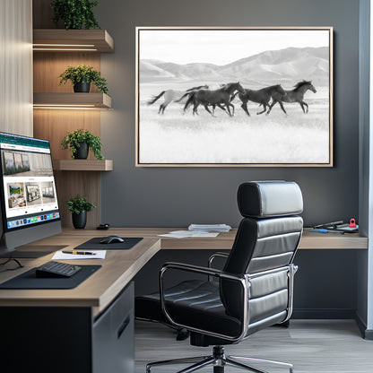 A black and white image of wild horses running freely across an open grassland, capturing the power and beauty of untamed nature in a rustic western setting.