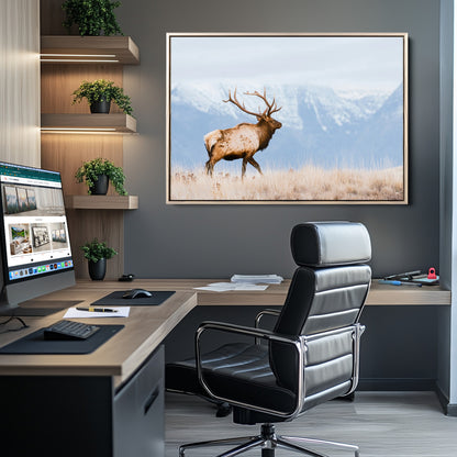 An elk walking on snowy grassland with majestic mountains in the background, ideal for rustic lodge or cabin wall decor.