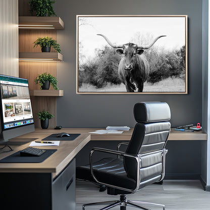 Black and white photo of a longhorn cow in a field, perfect for rustic farmhouse or western-themed interior wall decoration.