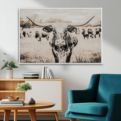 Canvas of a speckled Texas longhorn standing boldly in a field with a herd behind, perfect for rustic western or farmhouse wall decor.