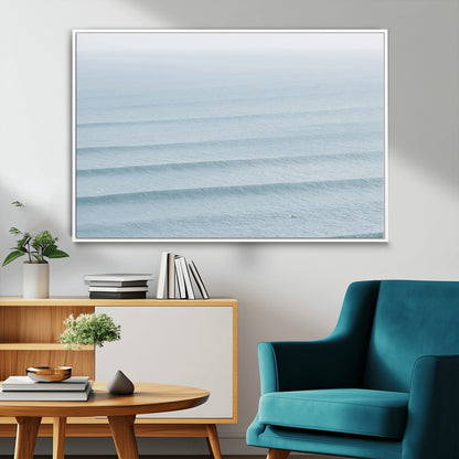 Framed canvas of repeating ocean waves with a distant solo surfer, ideal for minimalist ocean or calm coastal wall decor.