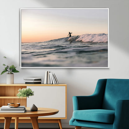 Framed canvas of a female surfer balancing on a wave at sunset, perfect for serene surf or ocean-inspired coastal decor.