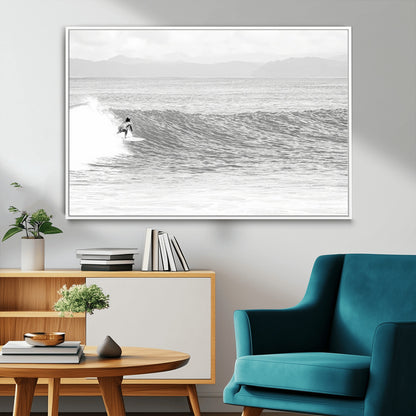 Monochrome photo of a surfer riding a wave with distant mountains, ideal for coastal motion or black and white surf-themed wall decor.
