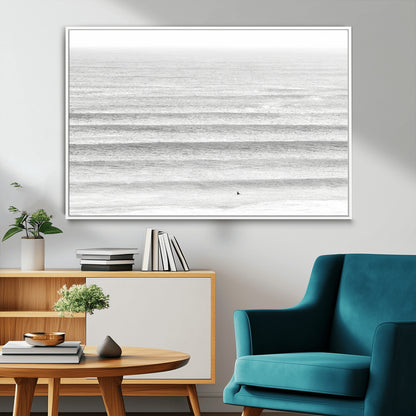 Monochrome photo of a lone surfer in calm layered waves, perfect for minimalist coastal or moody ocean-inspired wall decoration.
