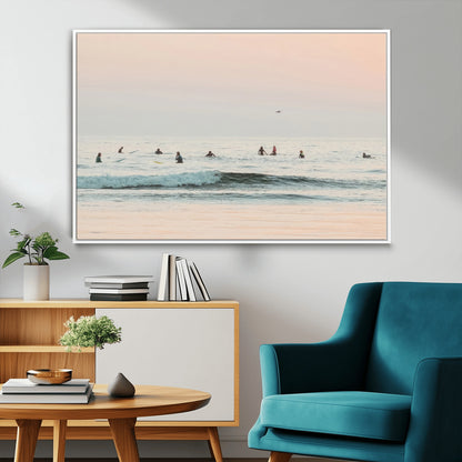 Dreamy photo of surfers waiting on soft pastel waves under a pink sunset sky, ideal for soft coastal minimalist or serene ocean-themed home decor.