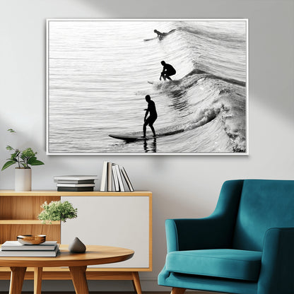 Black and white photo of surfers riding waves in a moody, high-contrast scene, ideal for modern coastal or surf-inspired home decor.