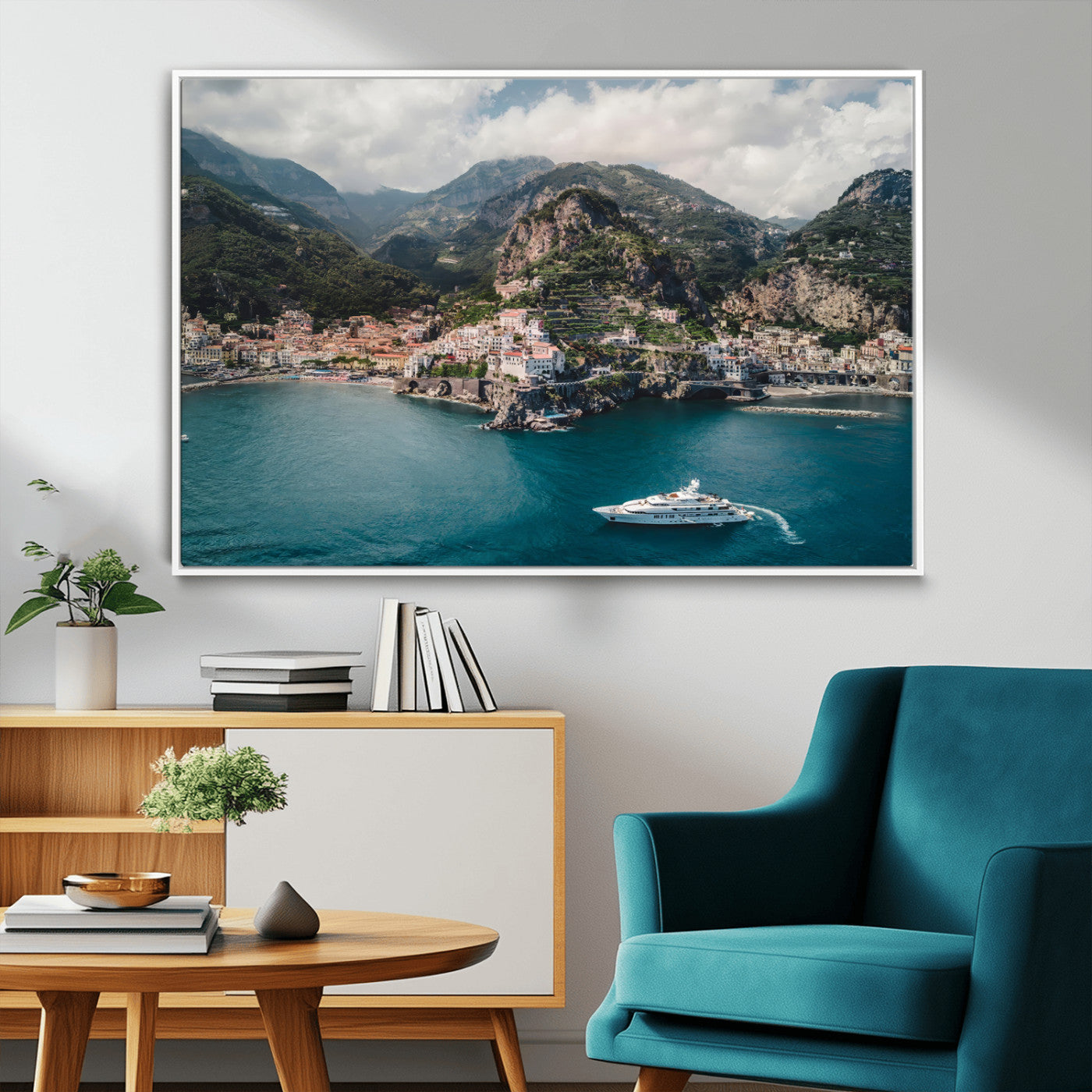 Aerial view of Amalfi Coast, Italy, with colorful hillside houses, lush green mountains, and a luxury yacht sailing in turquoise waters.