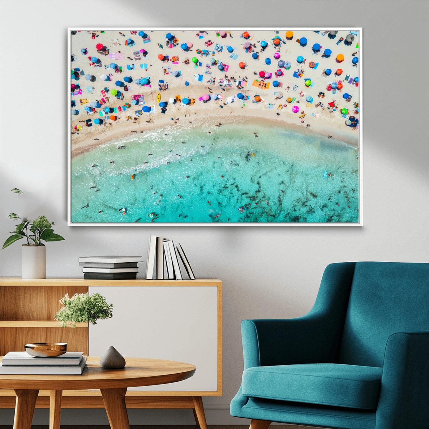 Aerial view of a vibrant beach filled with colorful umbrellas and people enjoying the turquoise ocean, capturing a lively summer vacation scene.
