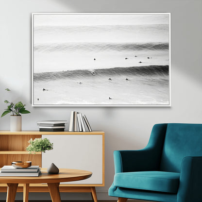 A monochrome photograph of swimmers gliding through gentle ocean waves, evoking a sense of calm and movement.
