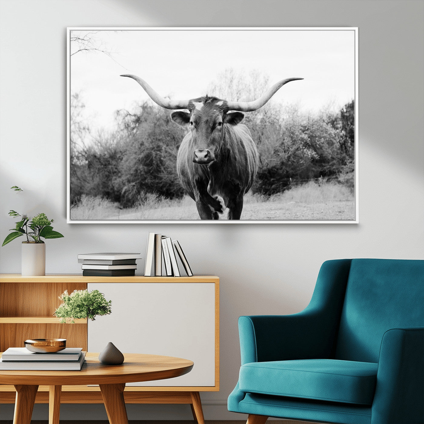 Black and white photo of a longhorn cow in a field, perfect for rustic farmhouse or western-themed interior wall decoration.