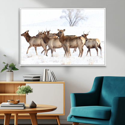 A group of elk standing on snowy terrain with a tree in the background, perfect for rustic or lodge-style winter wall decor.