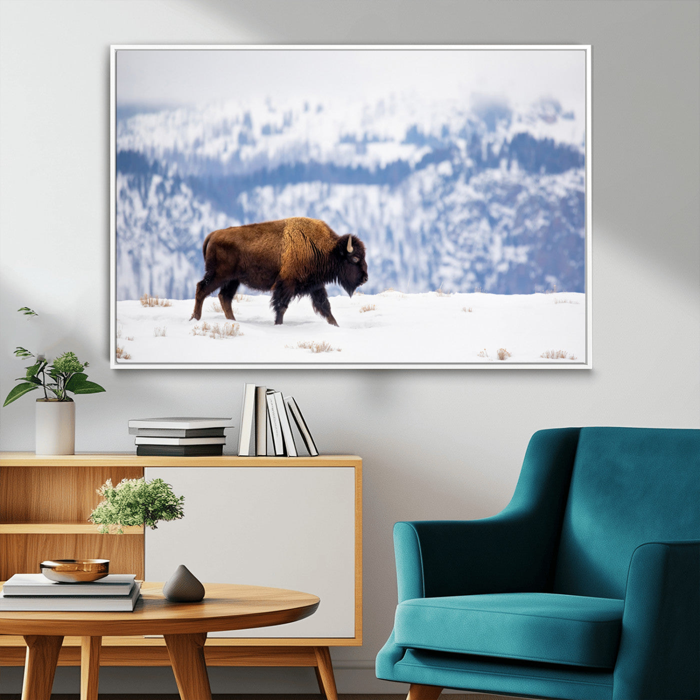A lone bison walks across snowy ground with blue-toned mountain range behind, ideal for rustic or western farmhouse interiors.