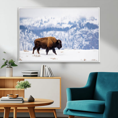A lone bison walks across snowy ground with blue-toned mountain range behind, ideal for rustic or western farmhouse interiors.