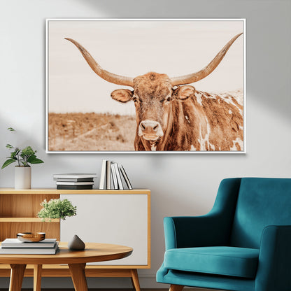 A longhorn bull standing proudly in a sunlit desert field with warm neutral tones, ideal for rustic western or farmhouse interiors.
