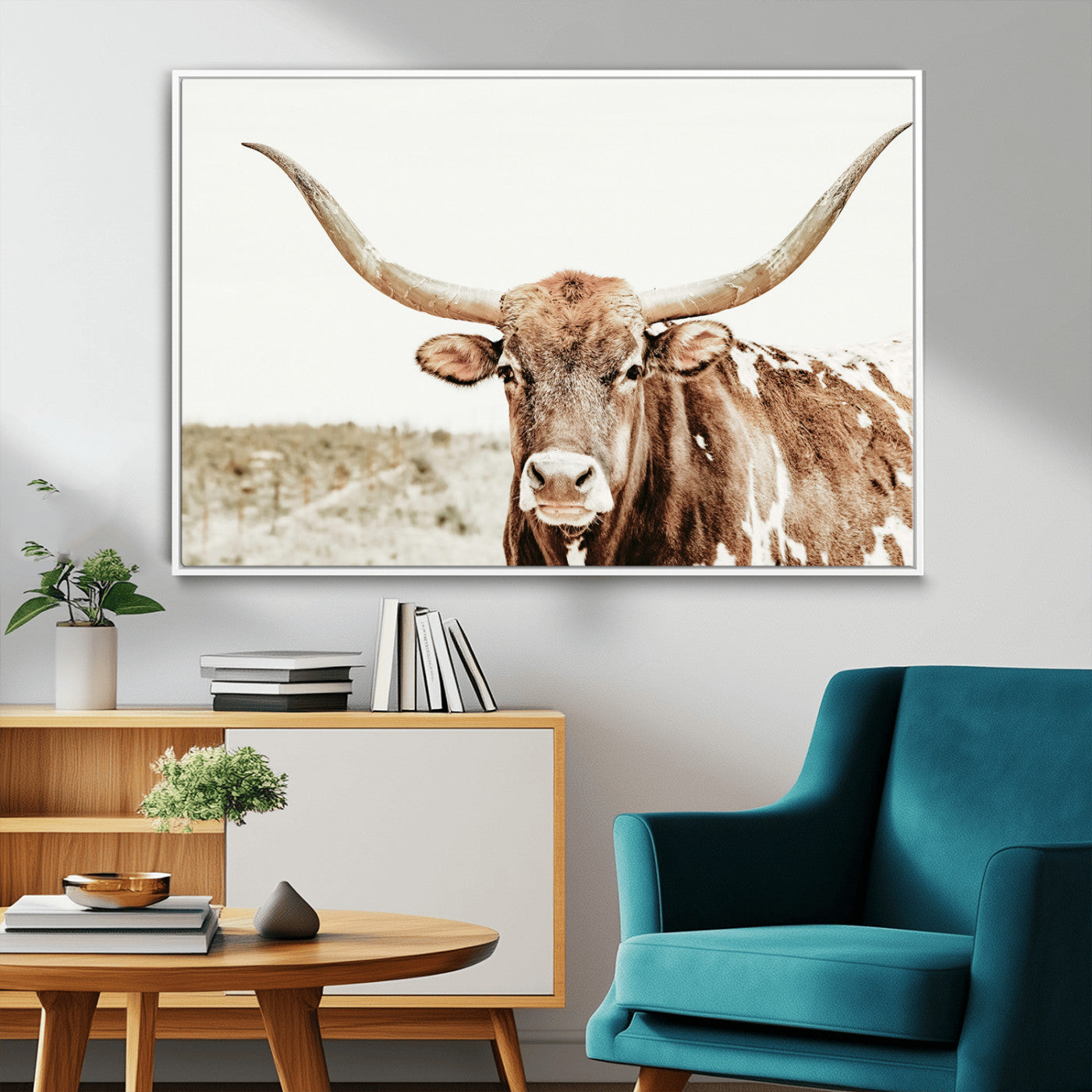 A Texas longhorn bull with wide horns, standing in a dry field under soft light, ideal for rustic farmhouse or western-themed interiors.