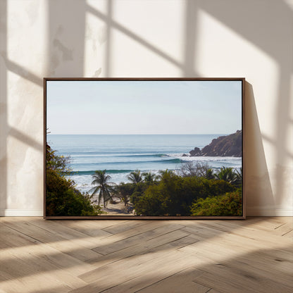 View of calm ocean waves with palm trees and a tropical coastline, ideal for coastal boho or beach-themed wall decor.