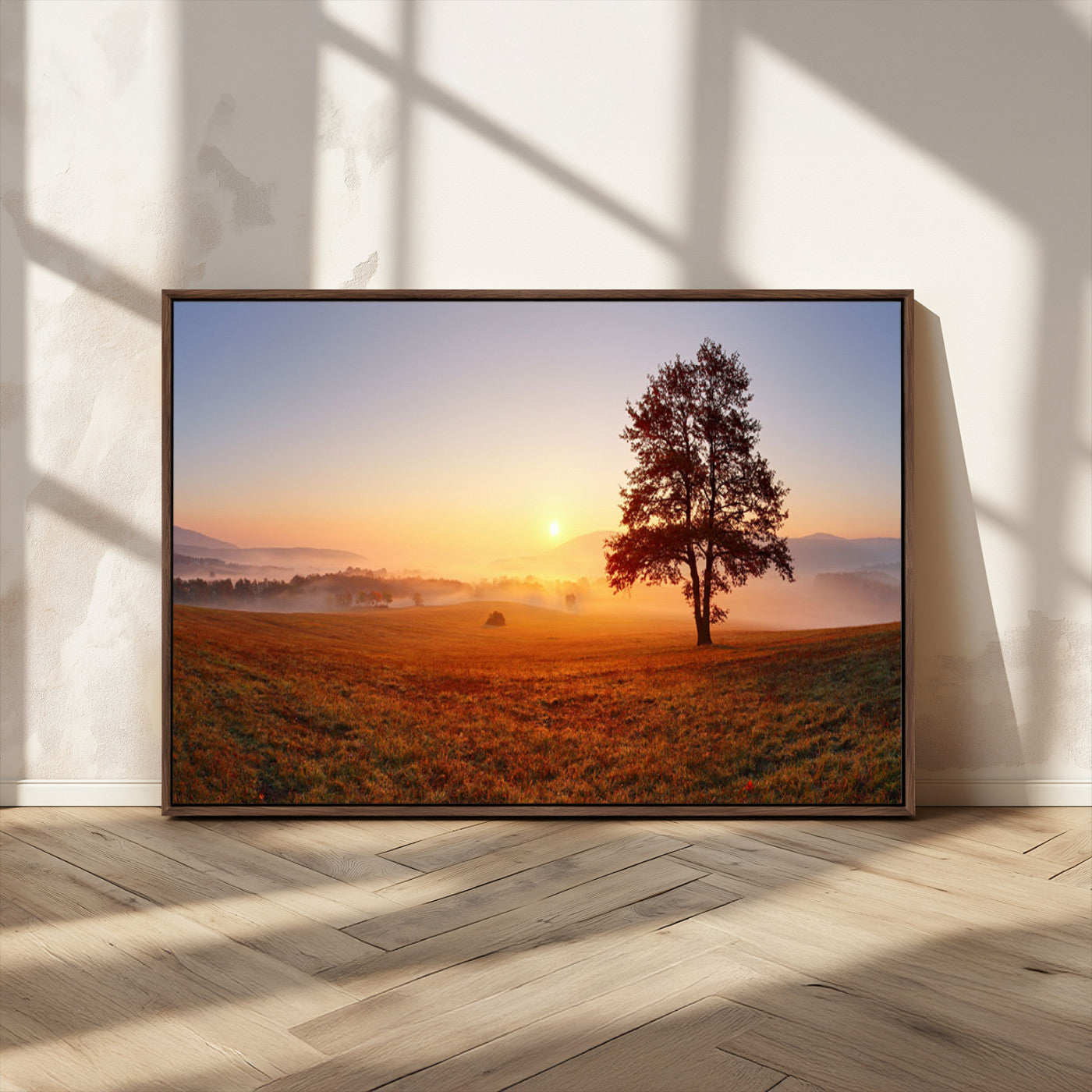 A tranquil landscape at sunrise with a mist-covered field and a lone tree, creating a peaceful and natural atmosphere.