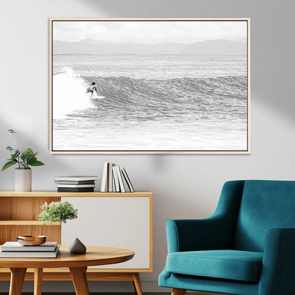Monochrome photo of a surfer riding a wave with distant mountains, ideal for coastal motion or black and white surf-themed wall decor.