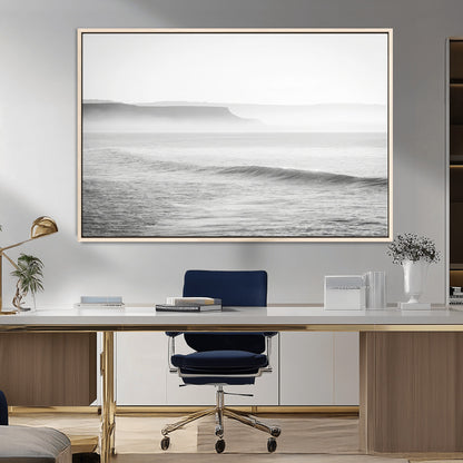 A black and white minimalist seascape featuring soft rolling waves and misty distant cliffs, creating a serene and timeless coastal atmosphere.