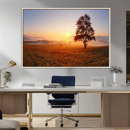 A tranquil landscape at sunrise with a mist-covered field and a lone tree, creating a peaceful and natural atmosphere.