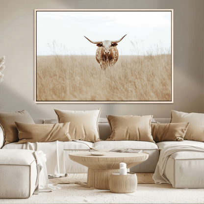 Texas Longhorn bull standing alone in dry grass with neutral tones, ideal for rustic western or cowboy-themed wall decor.