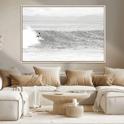 Monochrome photo of a surfer riding a wave with distant mountains, ideal for coastal motion or black and white surf-themed wall decor.